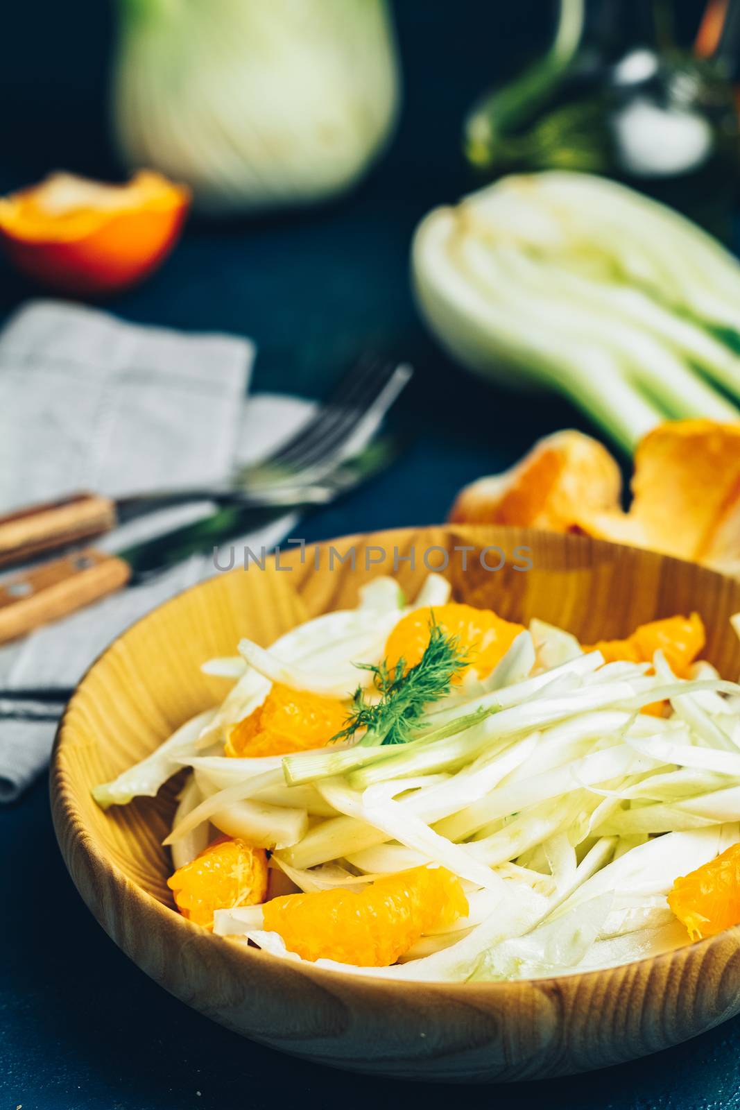 Fennel and orange citrus salad on wooden plate between ingredien by ArtSvitlyna
