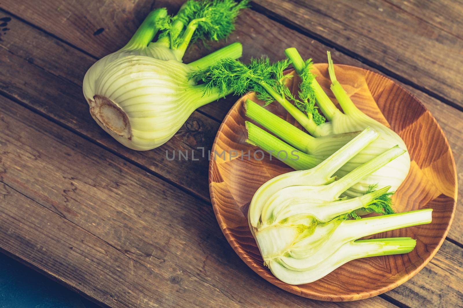 Fresh Florence fennel bulbs or Fennel bulb in plate on wooden background. Healthy and benefits of Florence fennel bulbs 