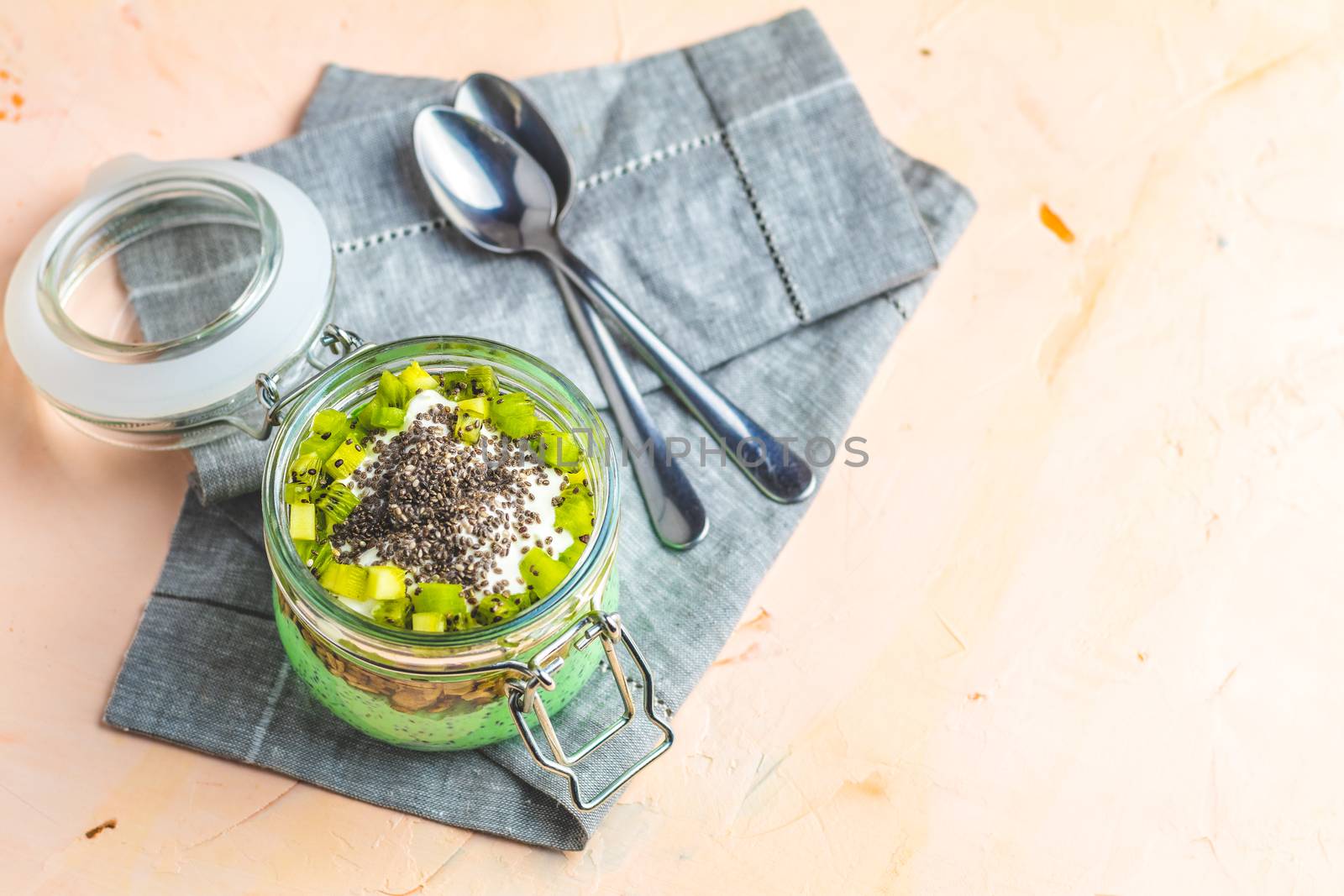 Chia seed pudding with matcha green tea on pink concrete backgro by ArtSvitlyna