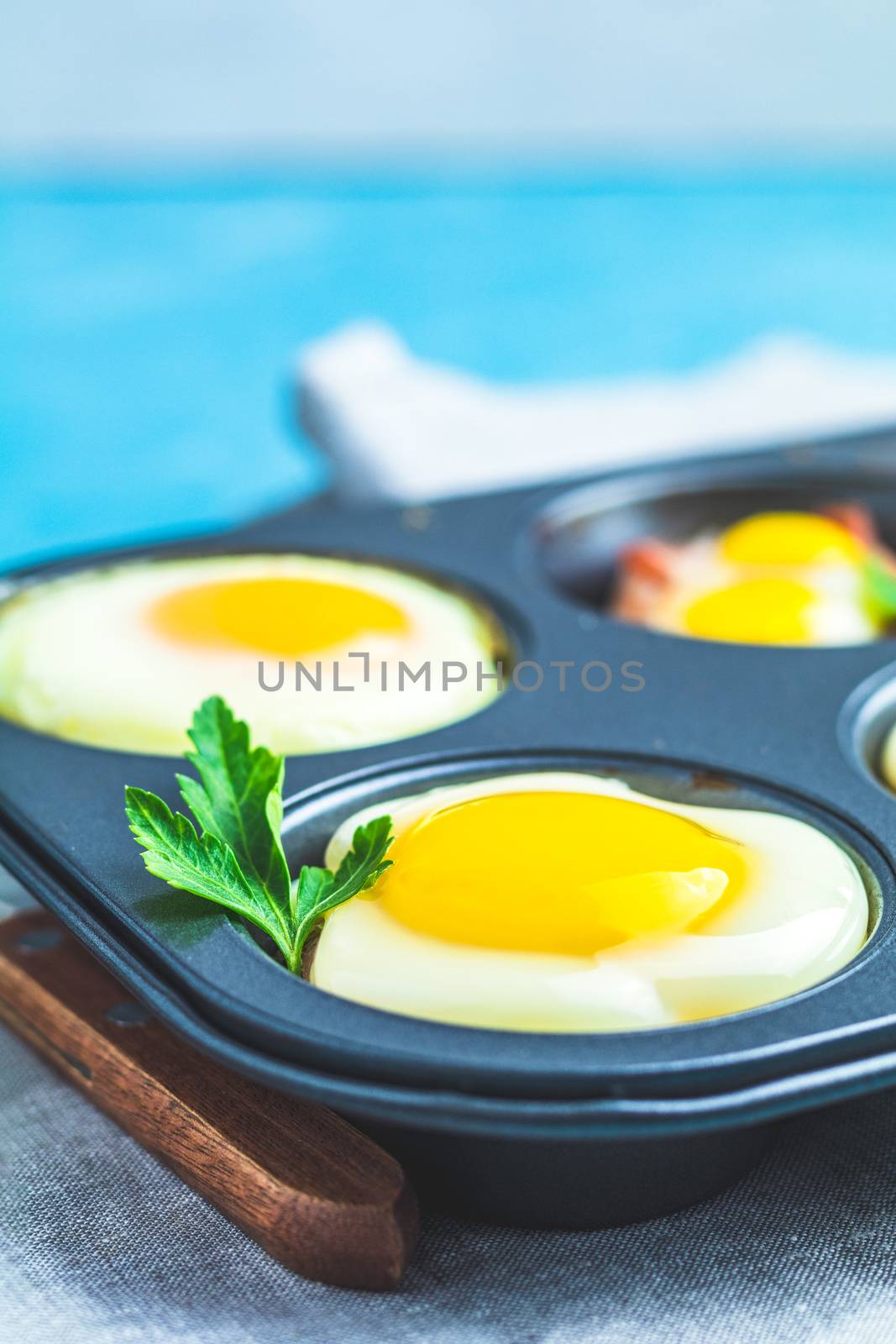 Baked eggs in baking molds. Portioned casserole from bacon sowbelly and eggs in Italian style.