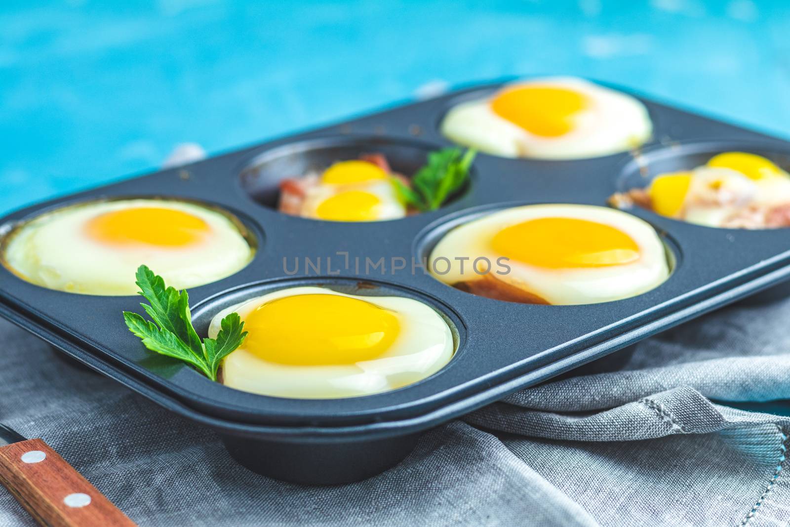 Baked eggs in baking molds. Portioned casserole from bacon sowbelly and eggs in Italian style.