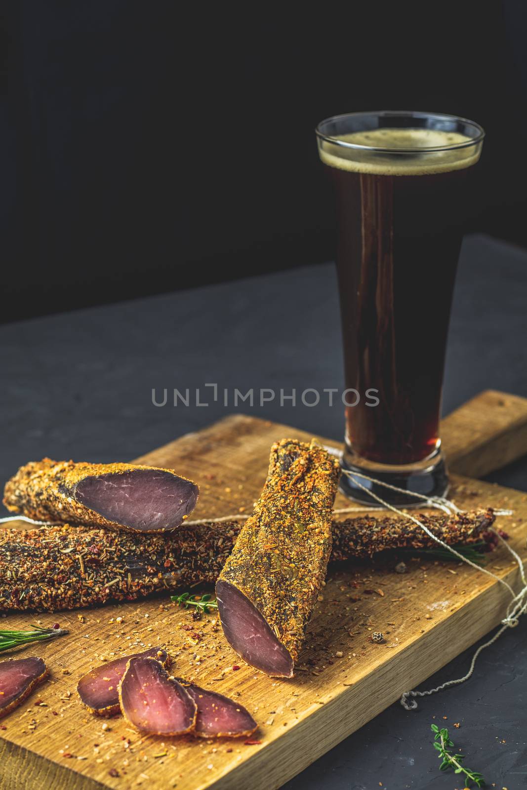 Dark beer in glass and Jerky, basturma, dried meat beef by ArtSvitlyna