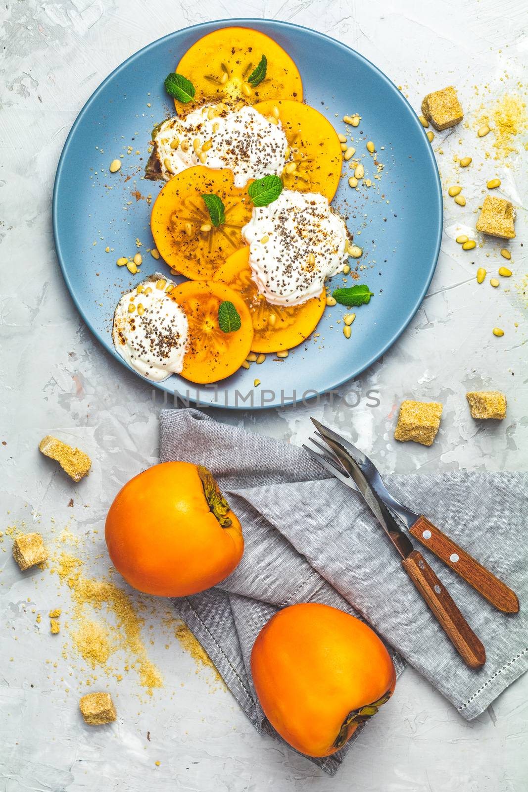 Sliced persimmon with yogurt, chia seeds, brown sugar, pine nuts by ArtSvitlyna