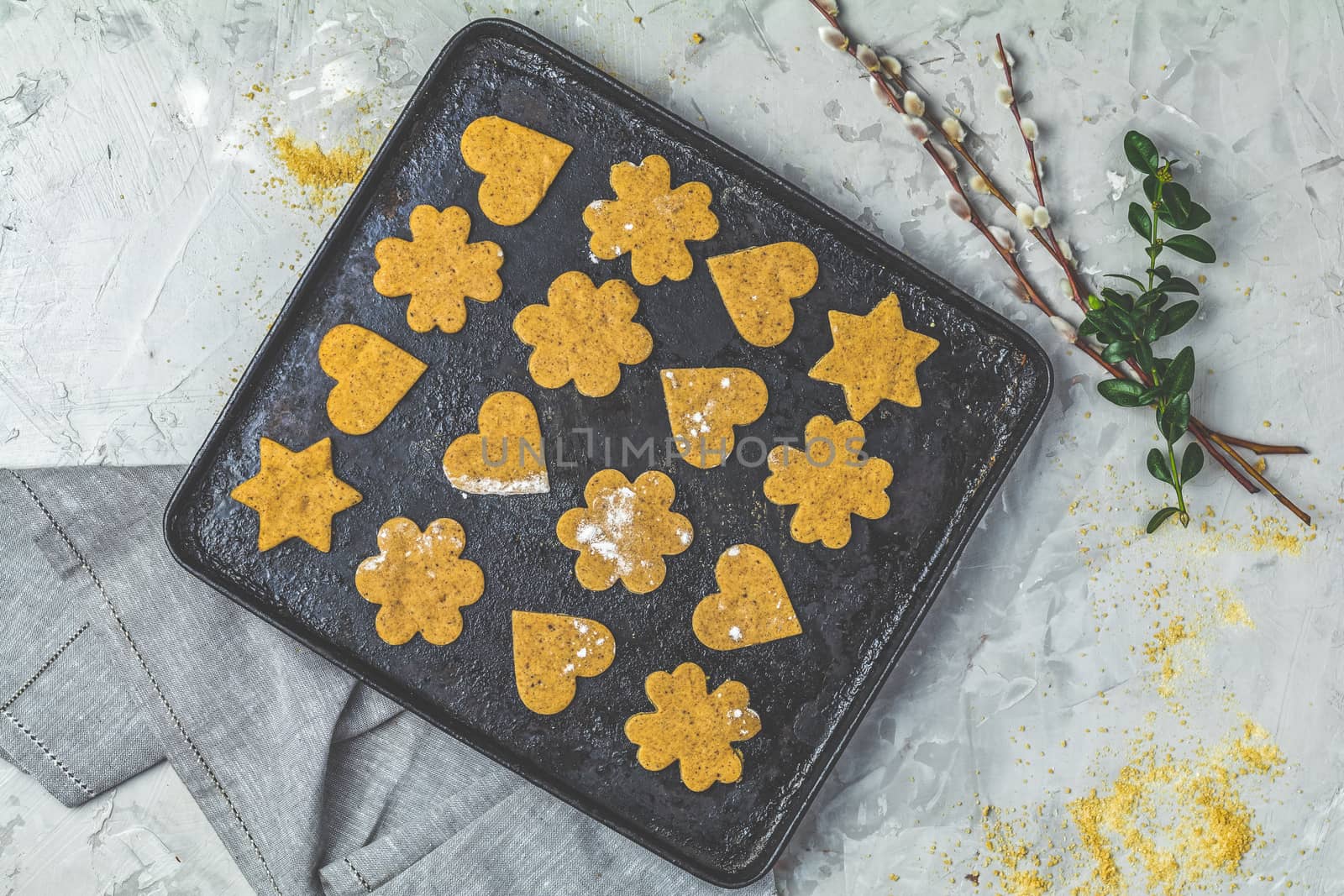 Culinary Spring or Christmas food background. Raw uncooked ginger cookies in baking dish on light gray concrete surface. View from above, copy space for text