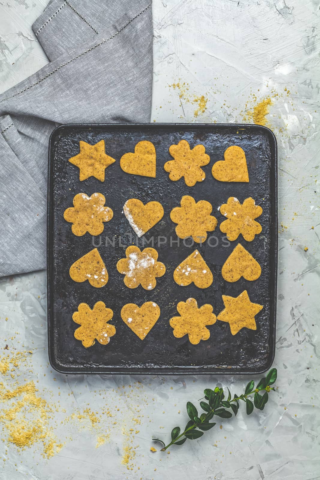 Culinary Spring or Christmas food background. Raw uncooked ginger cookies in baking dish on light gray concrete surface. View from above, copy space for text