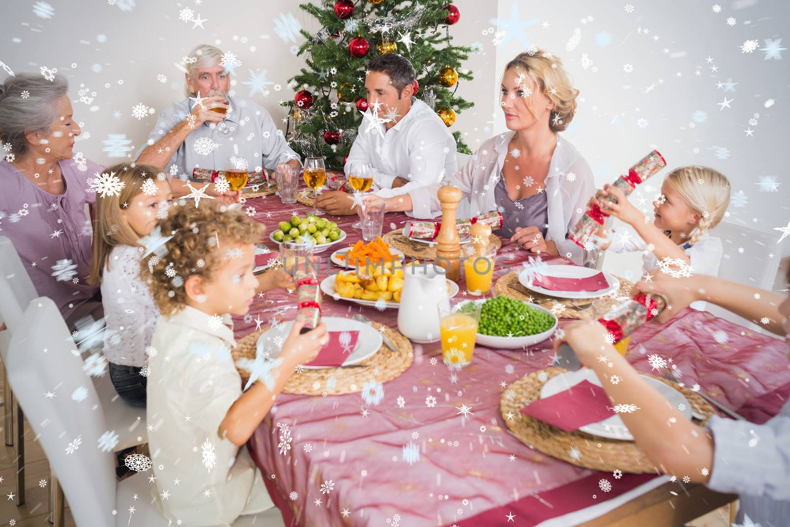 Composite image of Family having christmas dinner against snow