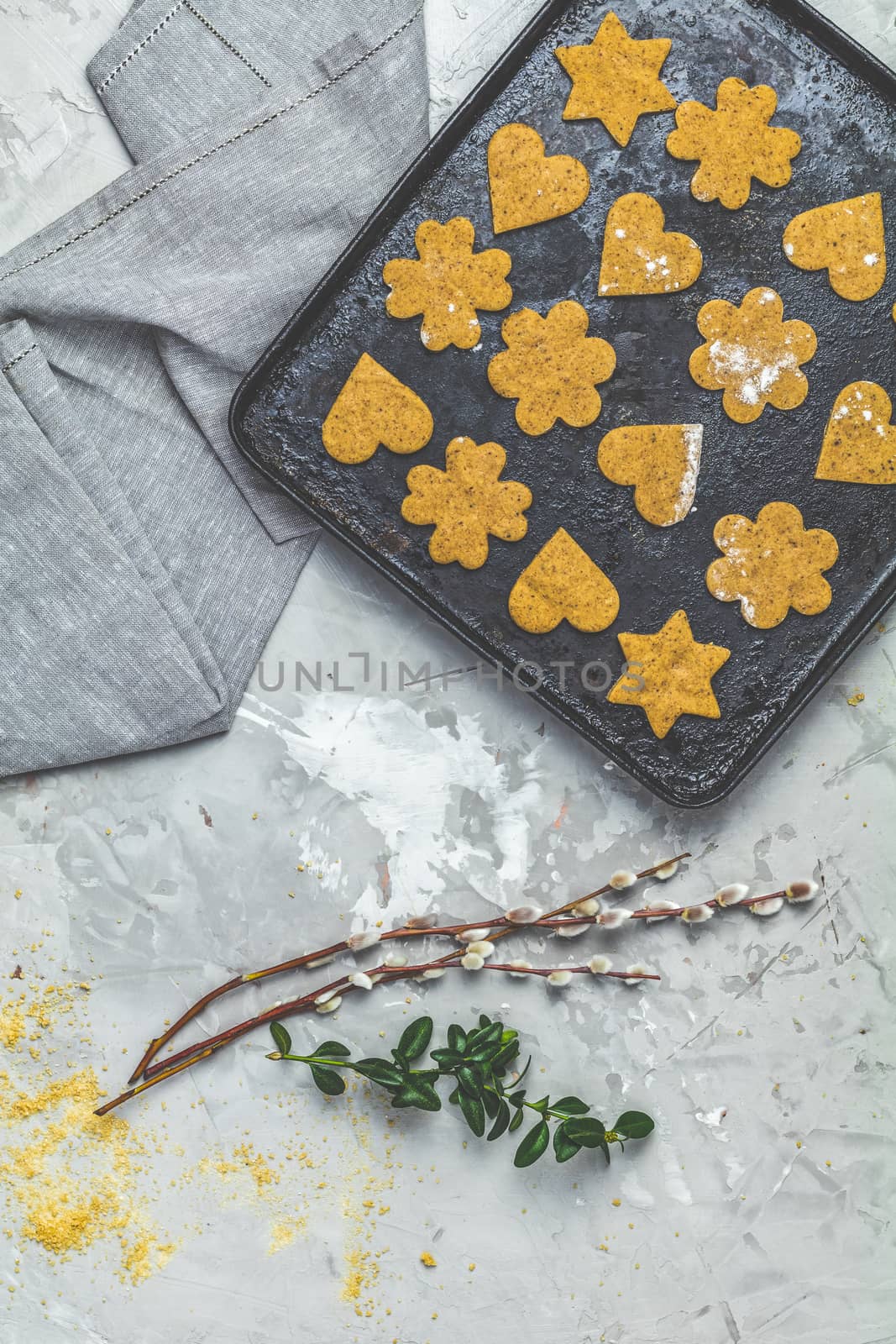 Culinary Spring or Christmas food background. Raw uncooked ginger cookies in baking dish on light gray concrete surface. View from above, copy space for text