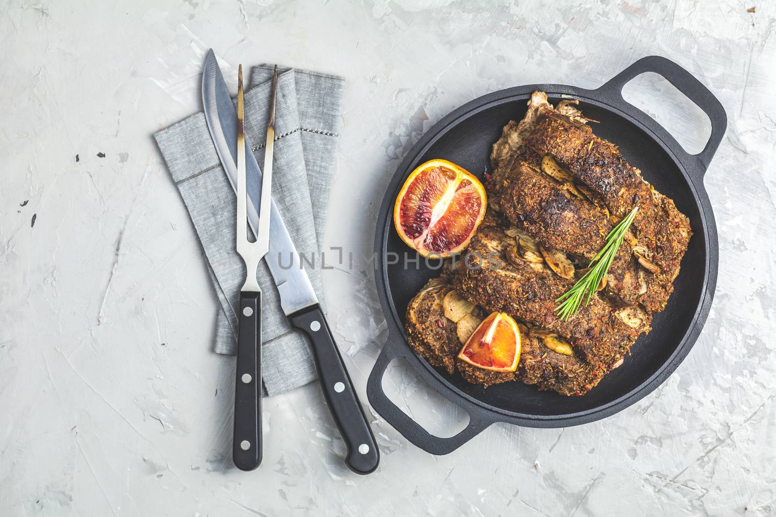 Delicious baked roast pork meat in black frying pan with garlic,  and spices. Dish for dinner. Top view, flat lay, copy space for you text