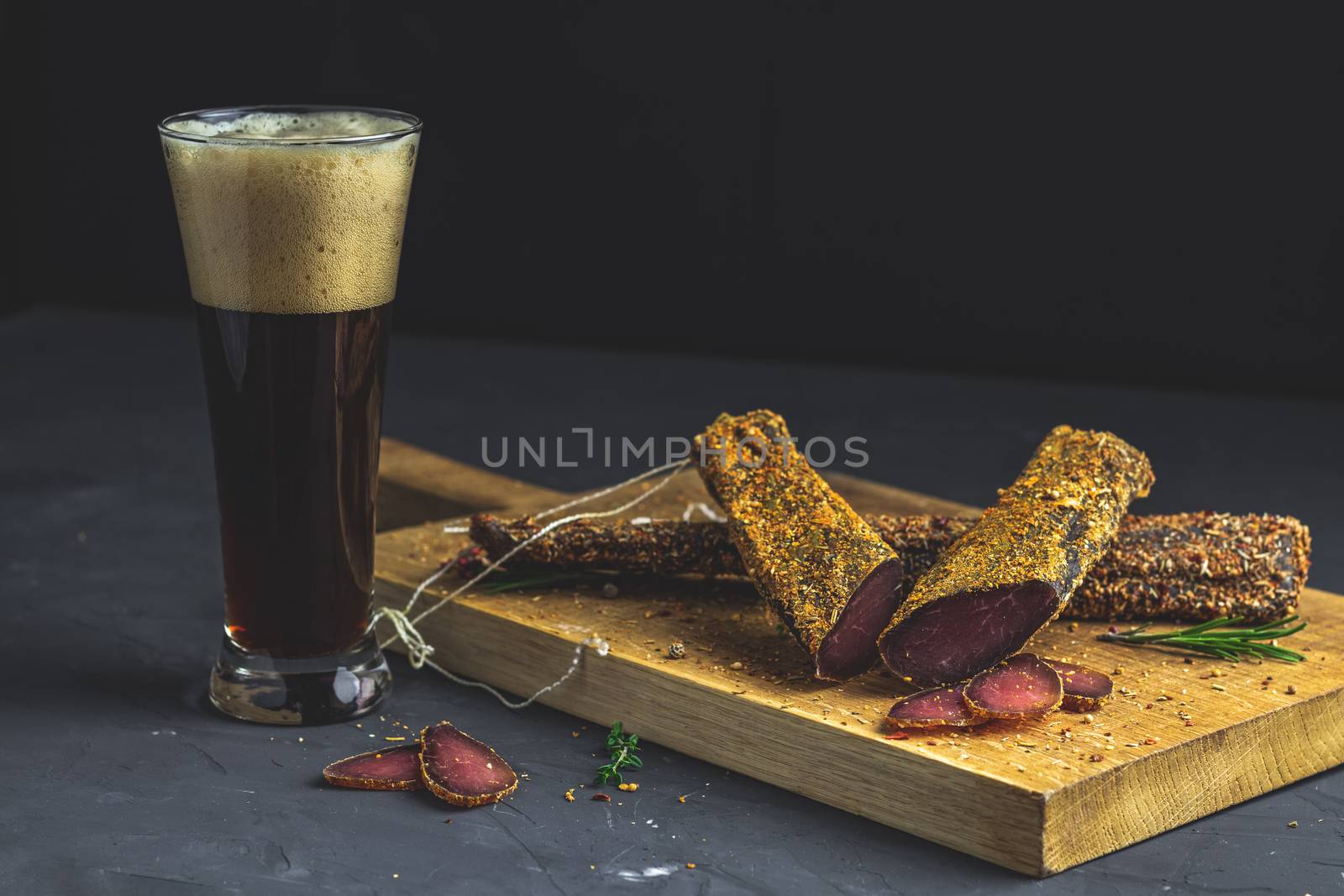 Dark beer in glass and Jerky, basturma, dried meat beef by ArtSvitlyna