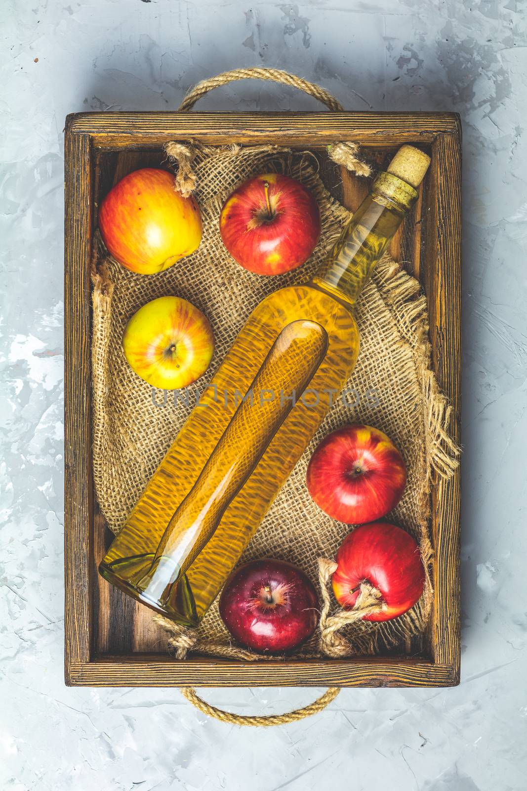 Bottle of homemade organic apple cider with apples in box by ArtSvitlyna