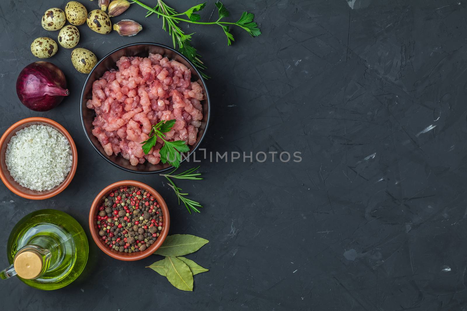 Homemade minced meat in a black bowl over dark slate by ArtSvitlyna