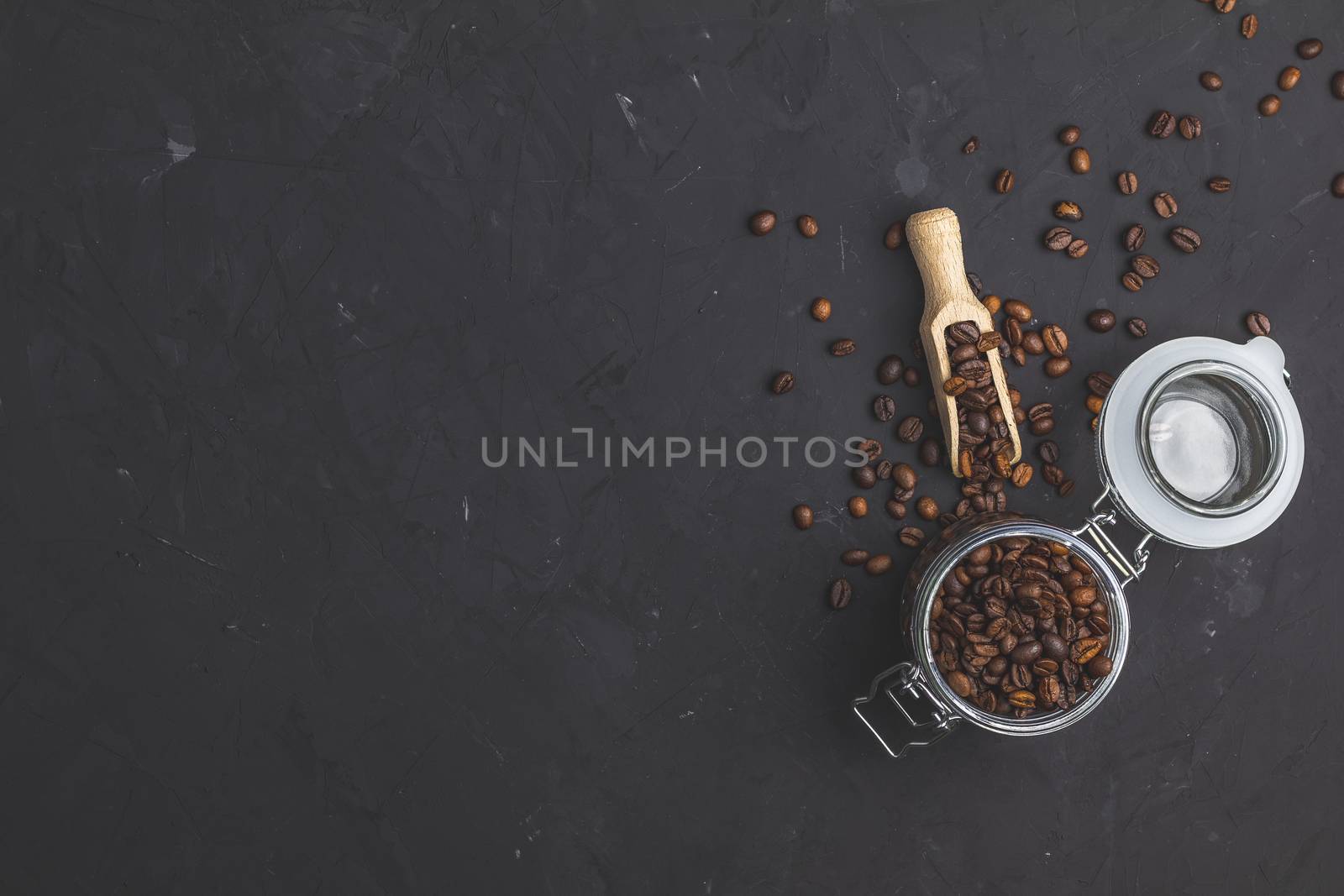 Glass jar with roasted beans and wooden scoop by ArtSvitlyna