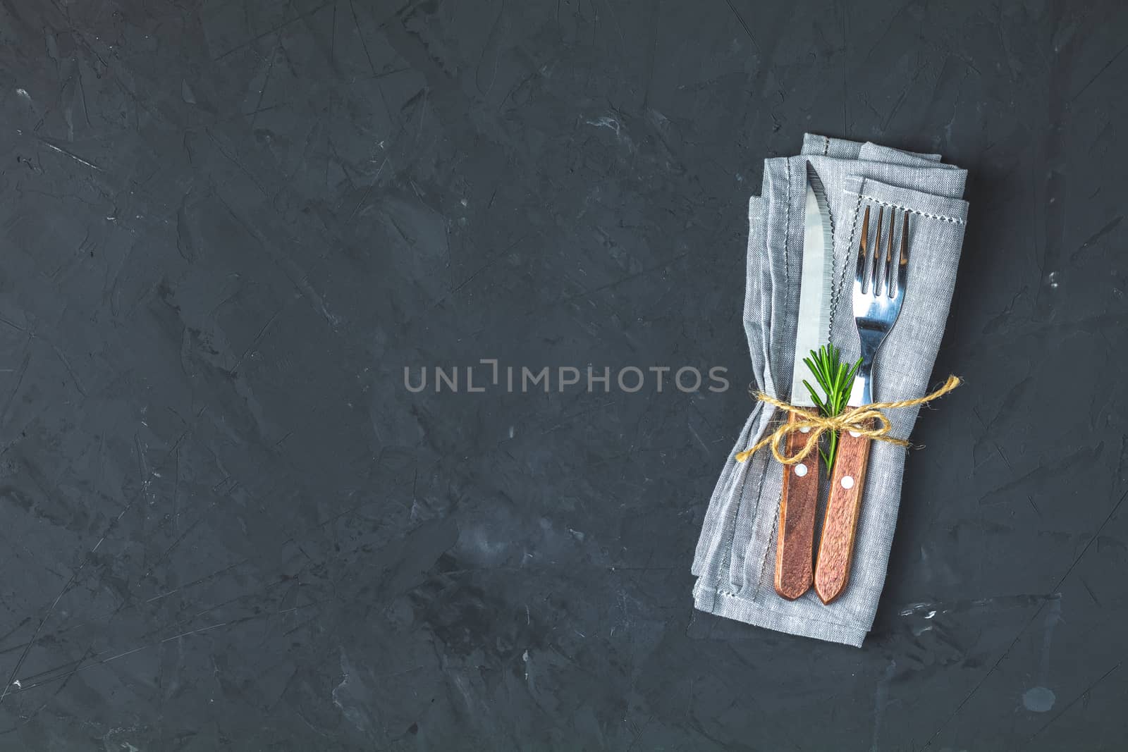 Rustic vintage set of cutlery knife, fork. Black stone concrete surface background. Top view, copy space.