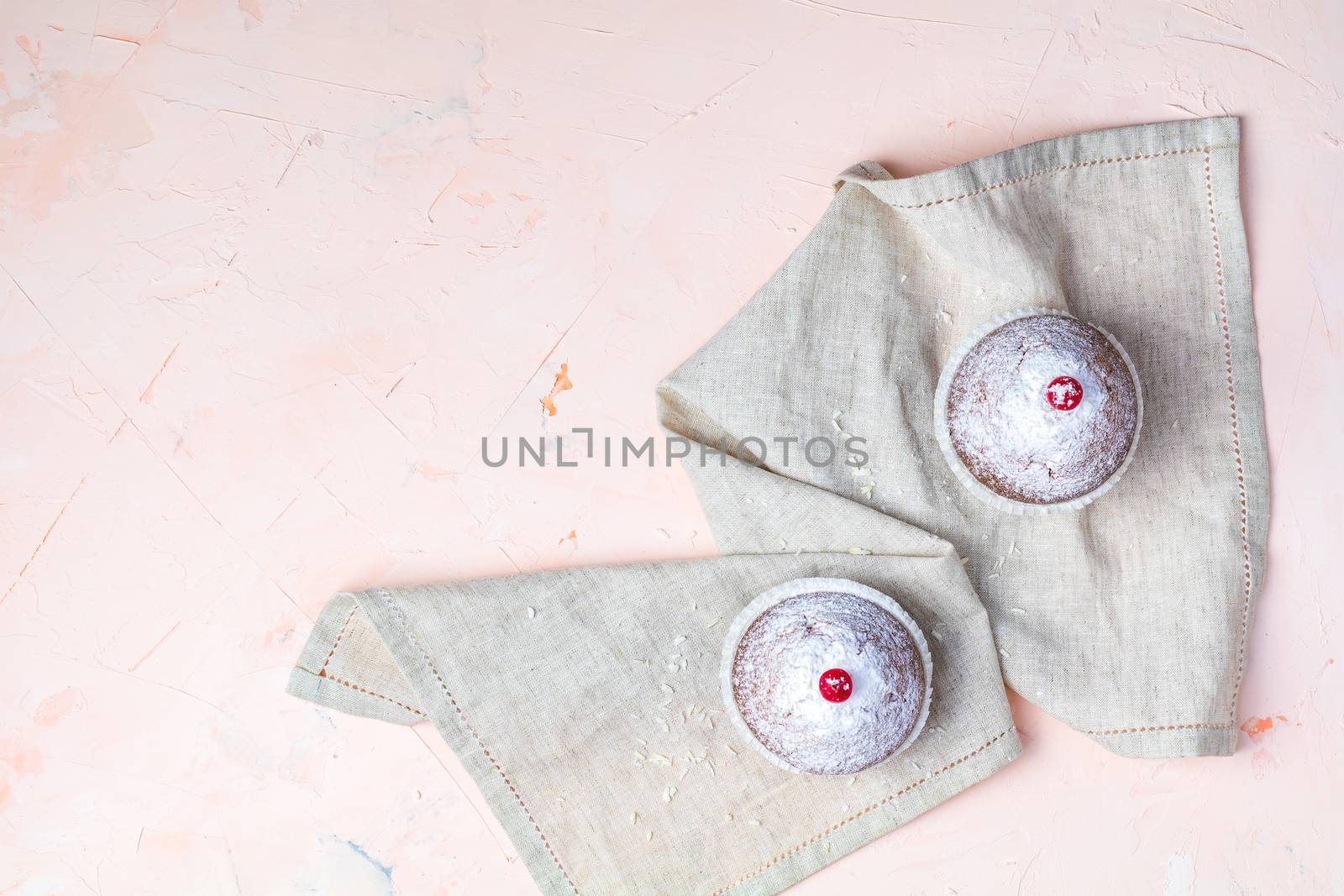 Tasty delicious homemade muffin on light pink living coral stone concrete surface, top view, copy space.