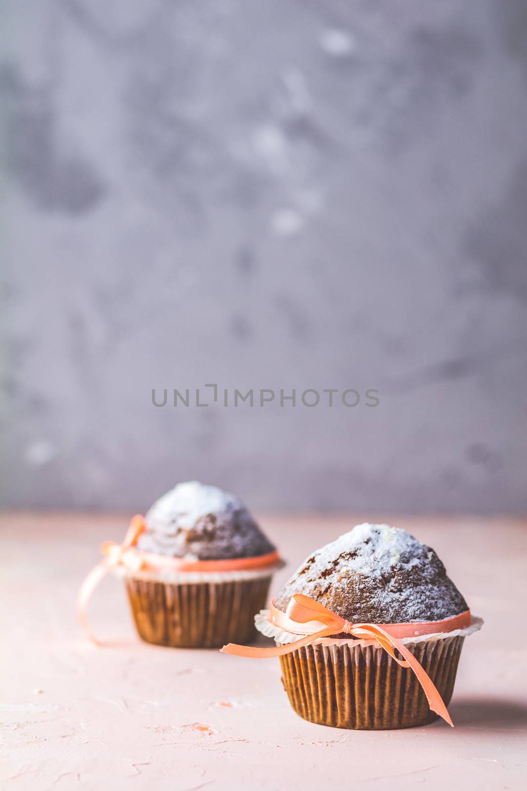 Tasty delicious homemade muffin on light pink living coral stone concrete surface, beautiful sweet food, copy space.