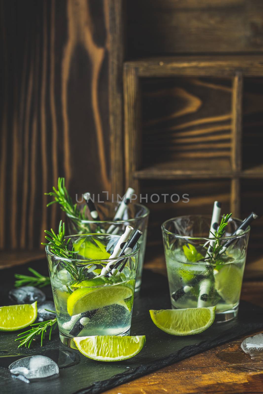 Fresh cocktail with lime, ice and rosemary, mojito cocktail in a by ArtSvitlyna