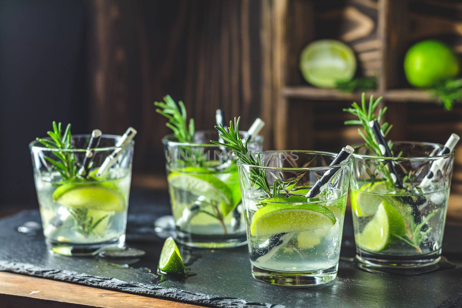 Fresh cocktail with lime, ice and rosemary by ArtSvitlyna