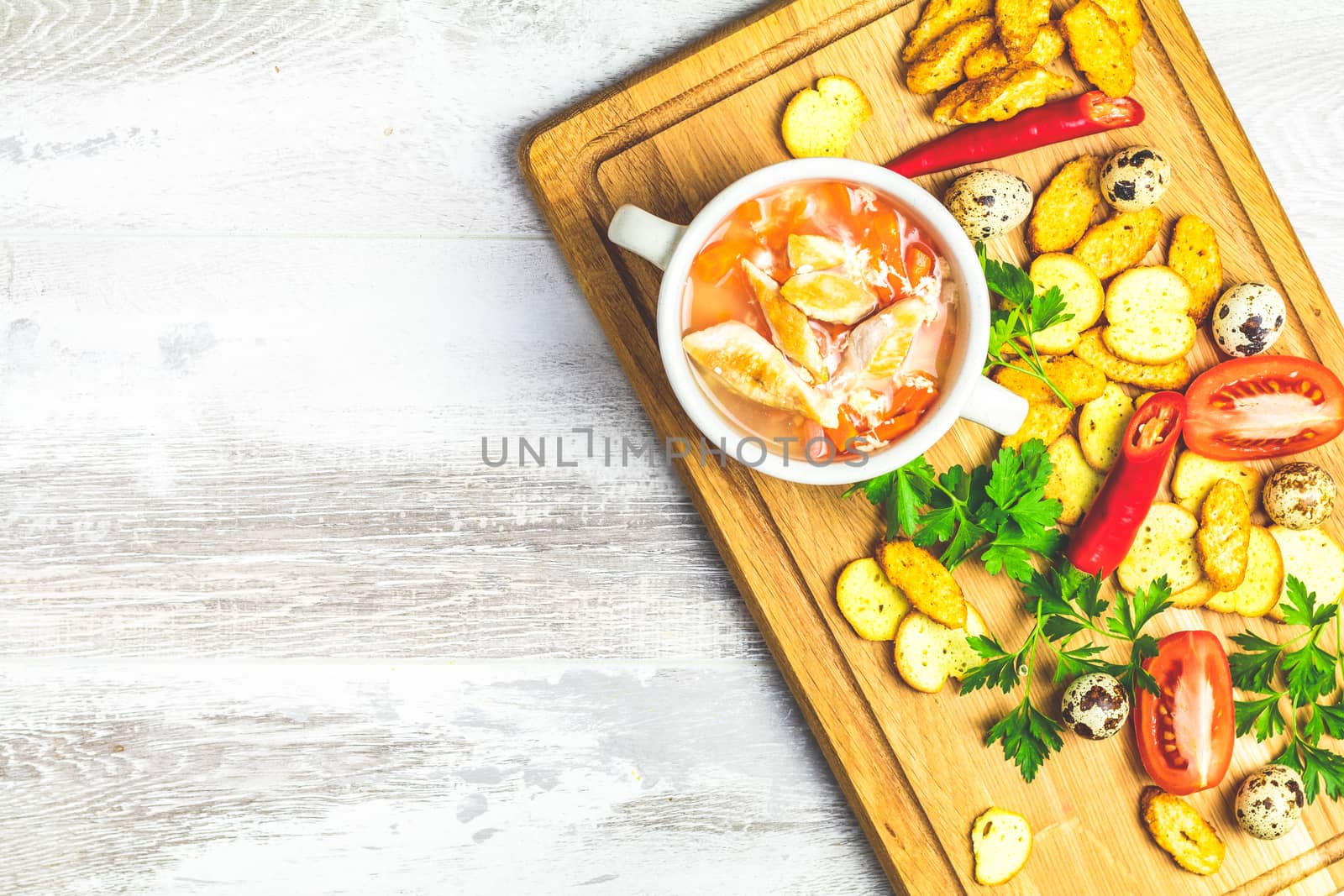 Concept of healthy vegetable and legume soups. Vegetables soup with carrot, eggs and chicken,  and ingredients. Top view on the background of a light gray wooden board, copy space