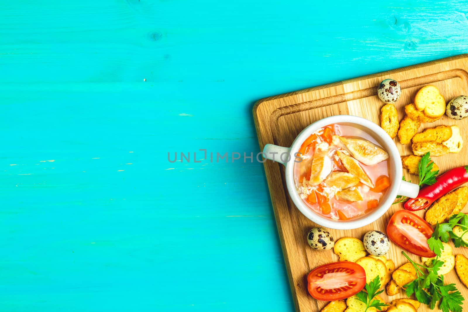 Concept of healthy vegetable and legume soups. Vegetables soup with carrot, eggs and chicken,  and ingredients. Top view on the background of a light gray wooden board, copy space
