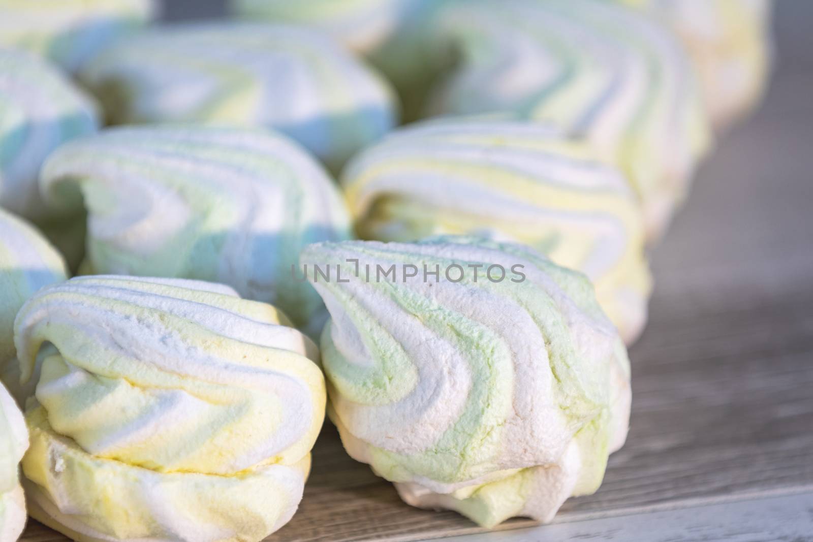 Background or texture of colorful marshmallows on light table background. Shallow depth of the field.