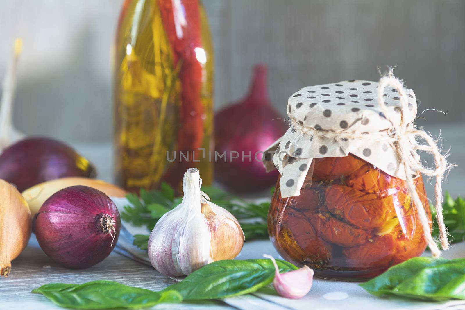 Sun dried tomatoes in glass jar on wooden background by ArtSvitlyna