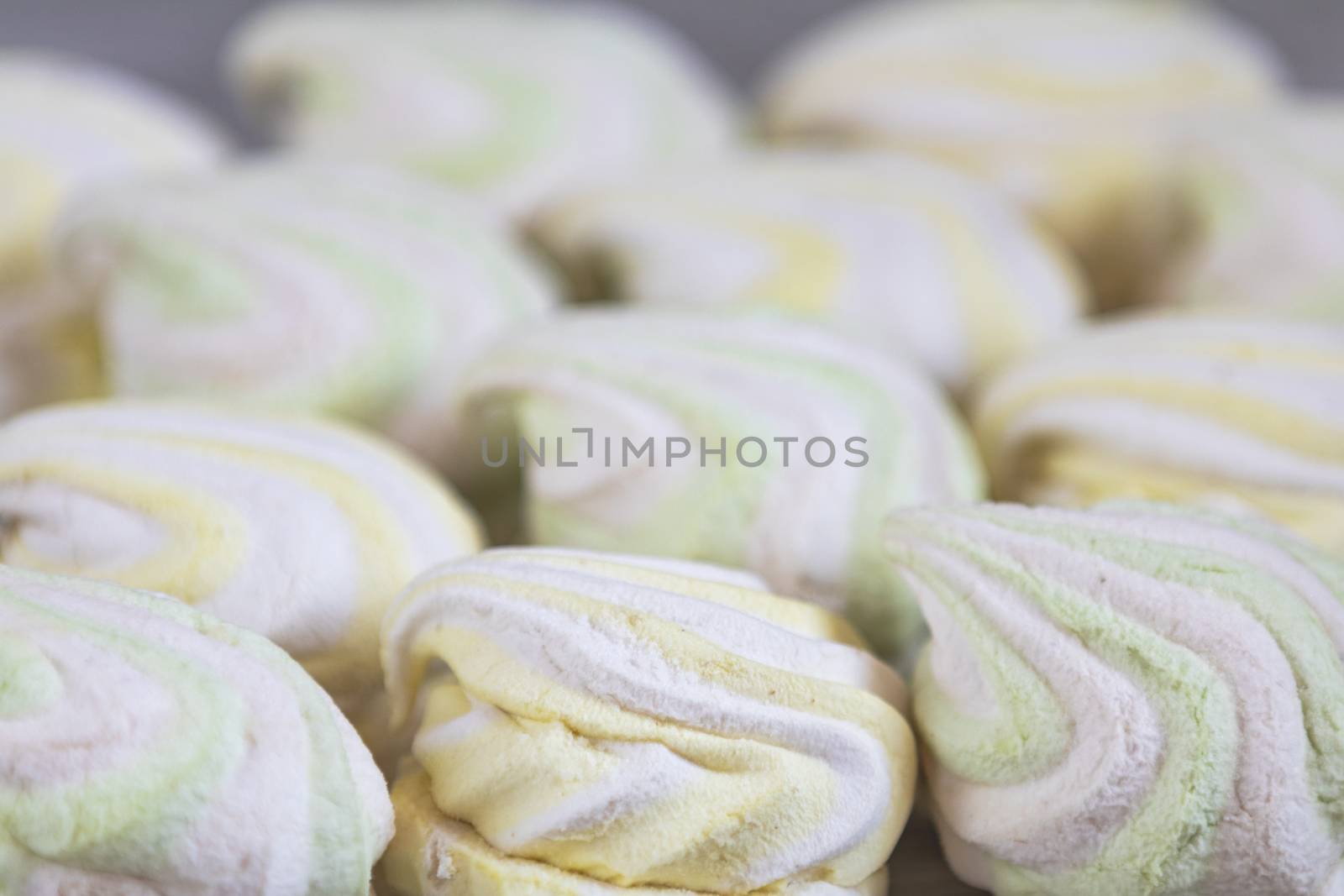 Background or texture of colorful marshmallows on light table background. Shallow depth of the field.