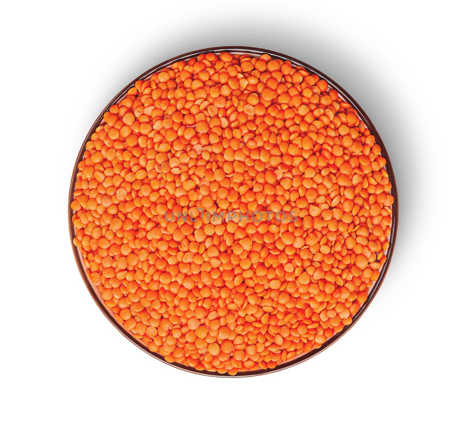 Orange lentils in bowl top view isolated on white background