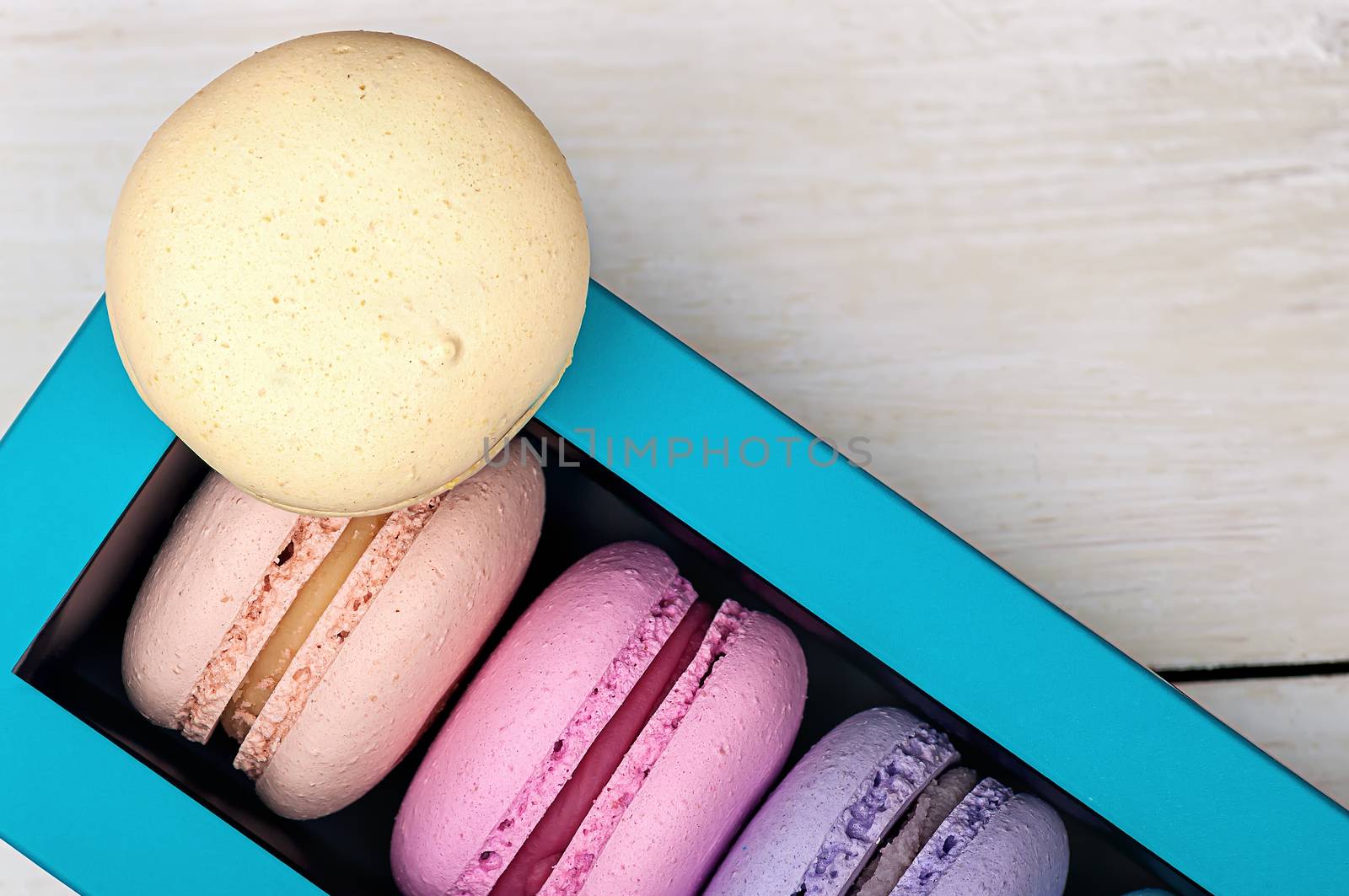Macaroons in box and one on top  by Cipariss