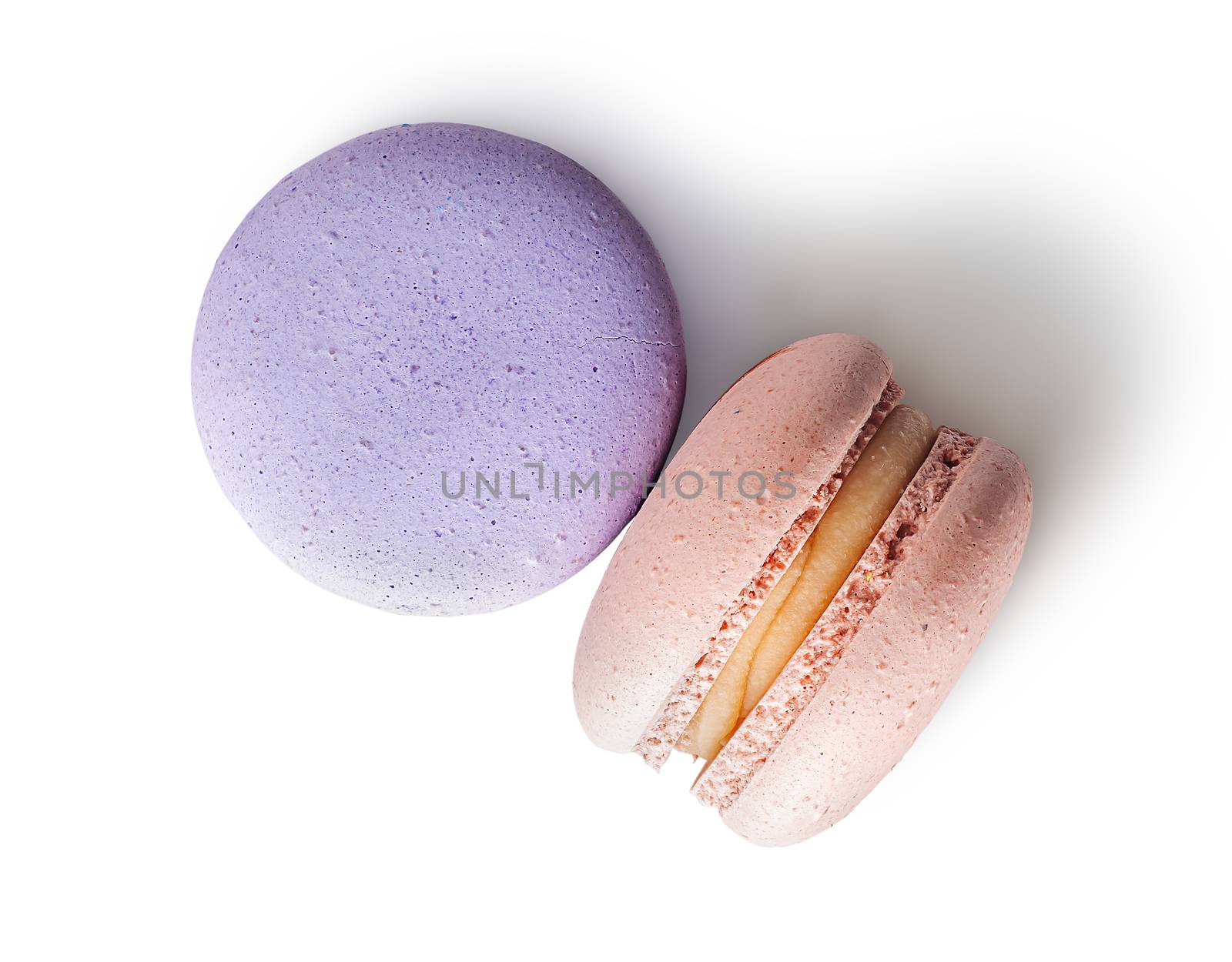 Two macaroon purple beige top view on white background