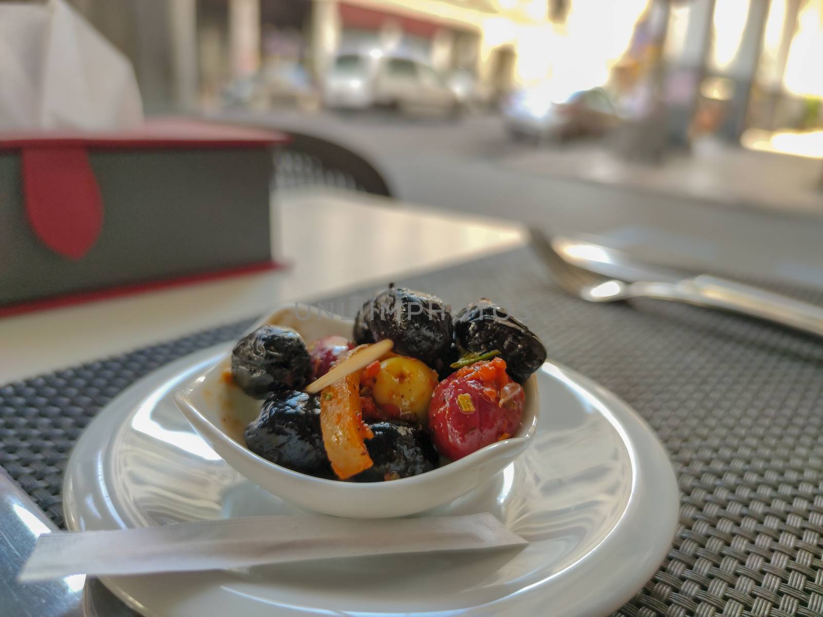 black red and yellow olives on a restaurant table
