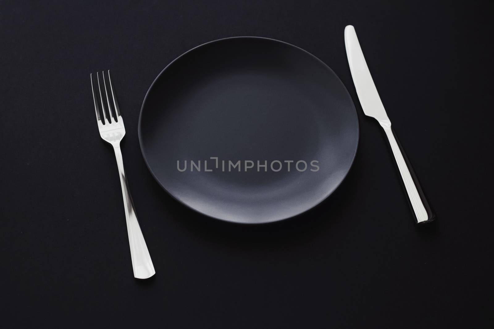 Empty plates and silverware on black background, premium tableware for holiday dinner, minimalistic design and diet by Anneleven