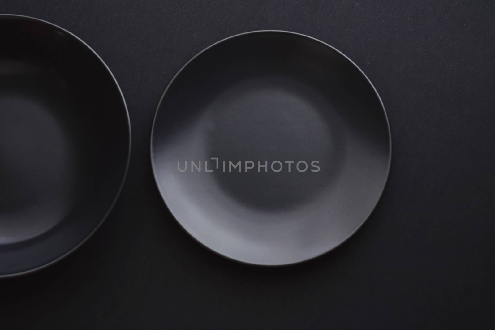 Empty plates on black background, premium dishware for holiday dinner, minimalistic design and diet concept