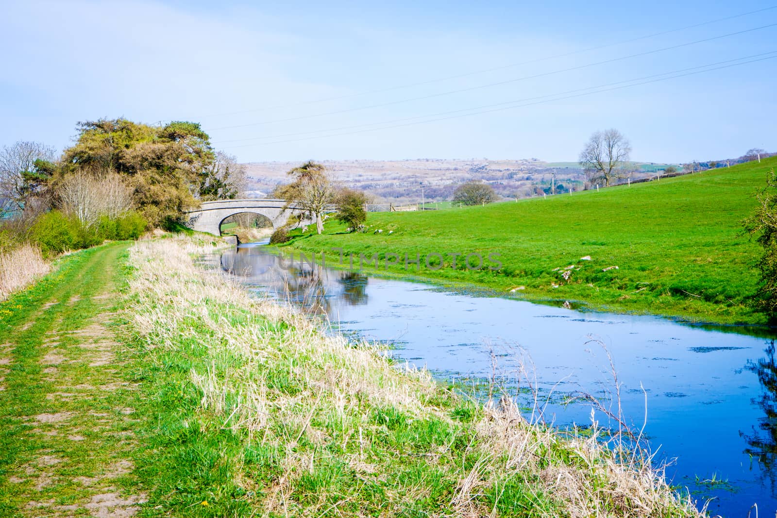 Scenic View of on the Lancster Canal Bathed in Warm Morning Sunlight Running through Cumbria England by paddythegolfer