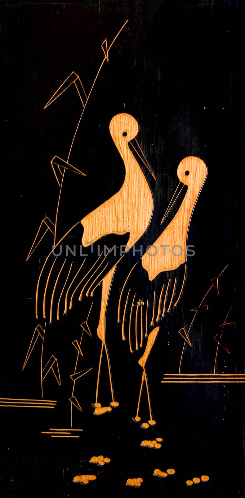 Two cranes stand in a swamp. Painting on a wooden plank.