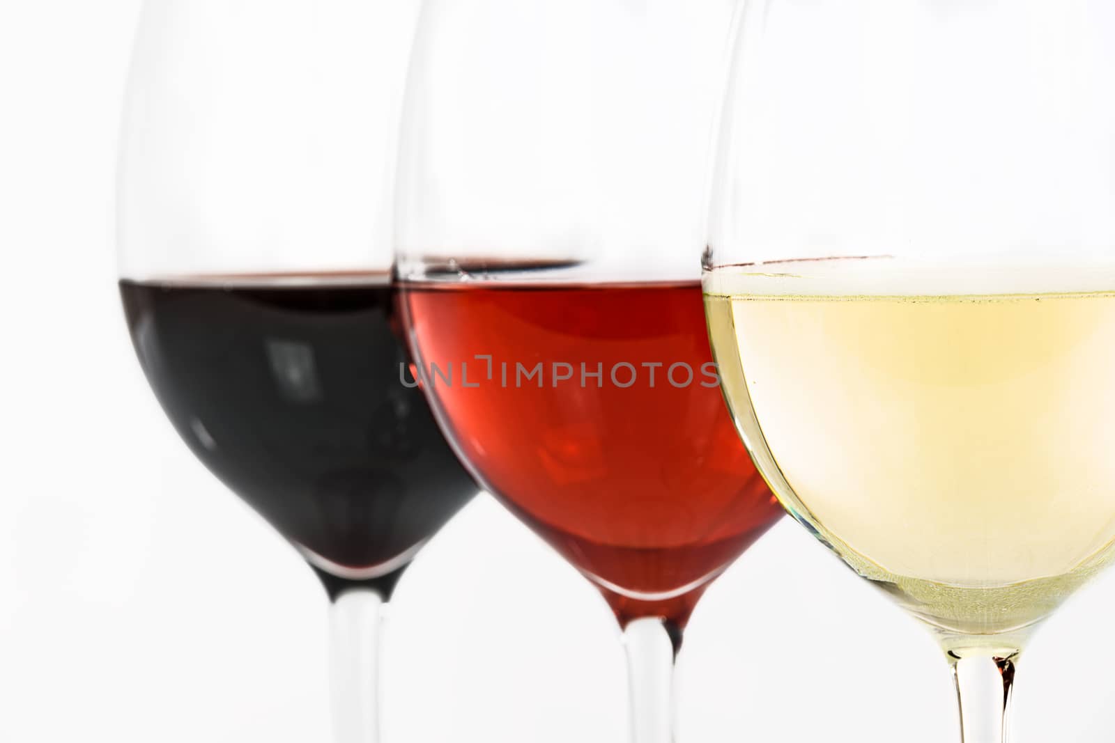 Three glasses of wine with white wine, rose and red on a white background