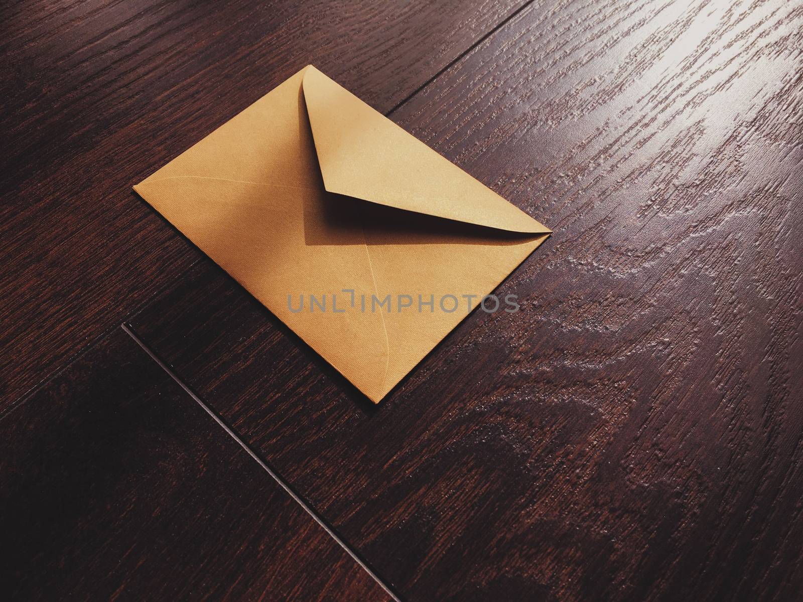 Golden vintage envelope on wooden background, newsletter and message concept