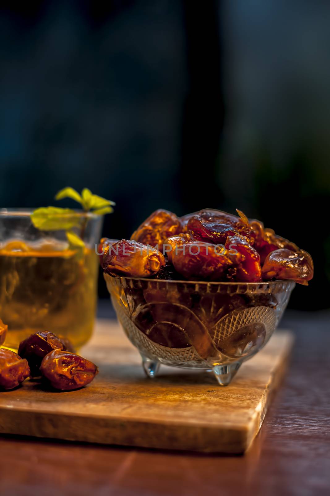 Close up of raw dates along with its syrup in a glass with some mint leaves on it which helps in weight loss, constipation aid and promotes heart health. by mirzamlk