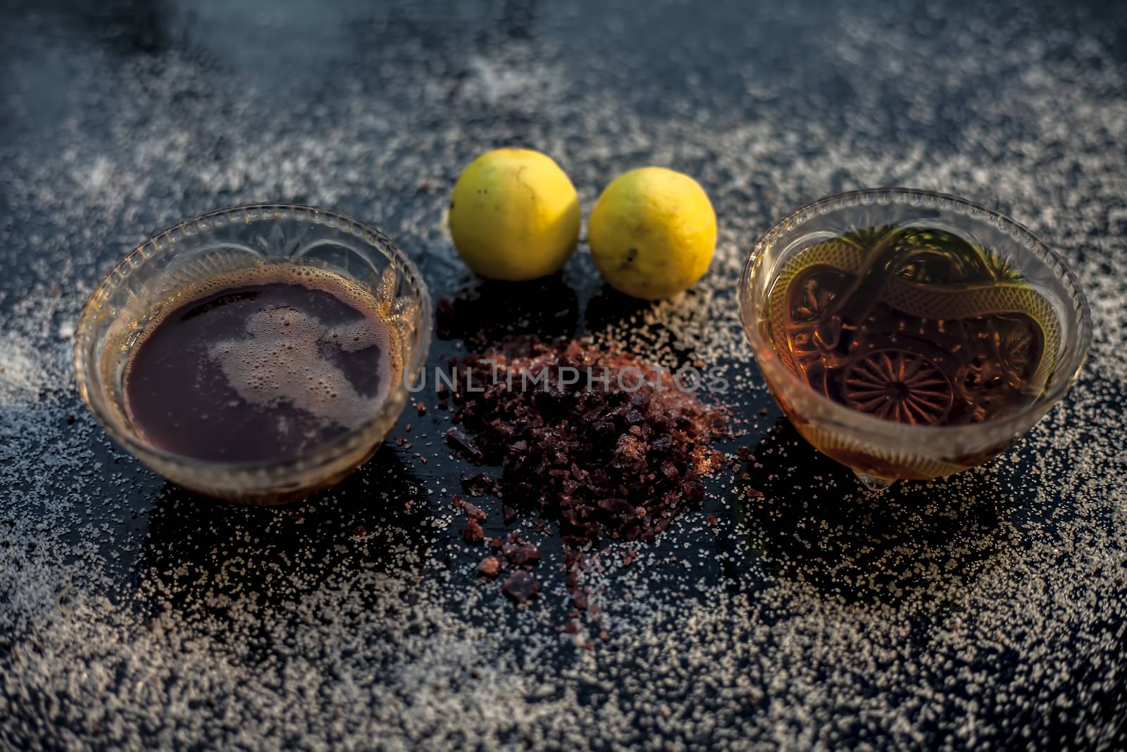 All-purpose ayurvedic salt face mask on the black wooden surface consisting of salt, rock salt, lemon juice, and honey. The face mask as well as a face pack. Horizontal top shot.
