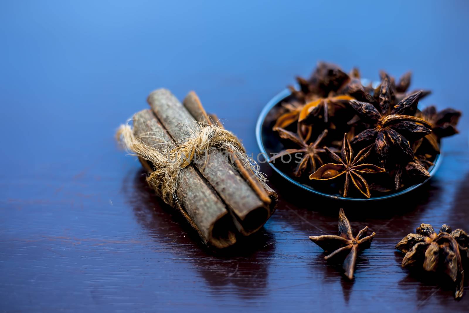 Face mask for wrinkles on the wooden surface consisting of some cinnamon sticks, water, and star anise seed powder.