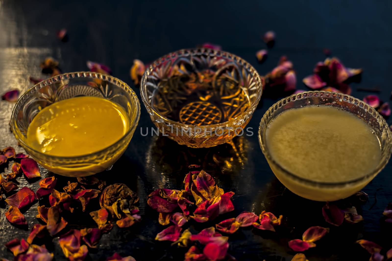 Ayurvedic moisturizer face mask on black glossy surface in a glass bowl with some ghee or clarified butter, honey and pack. by mirzamlk