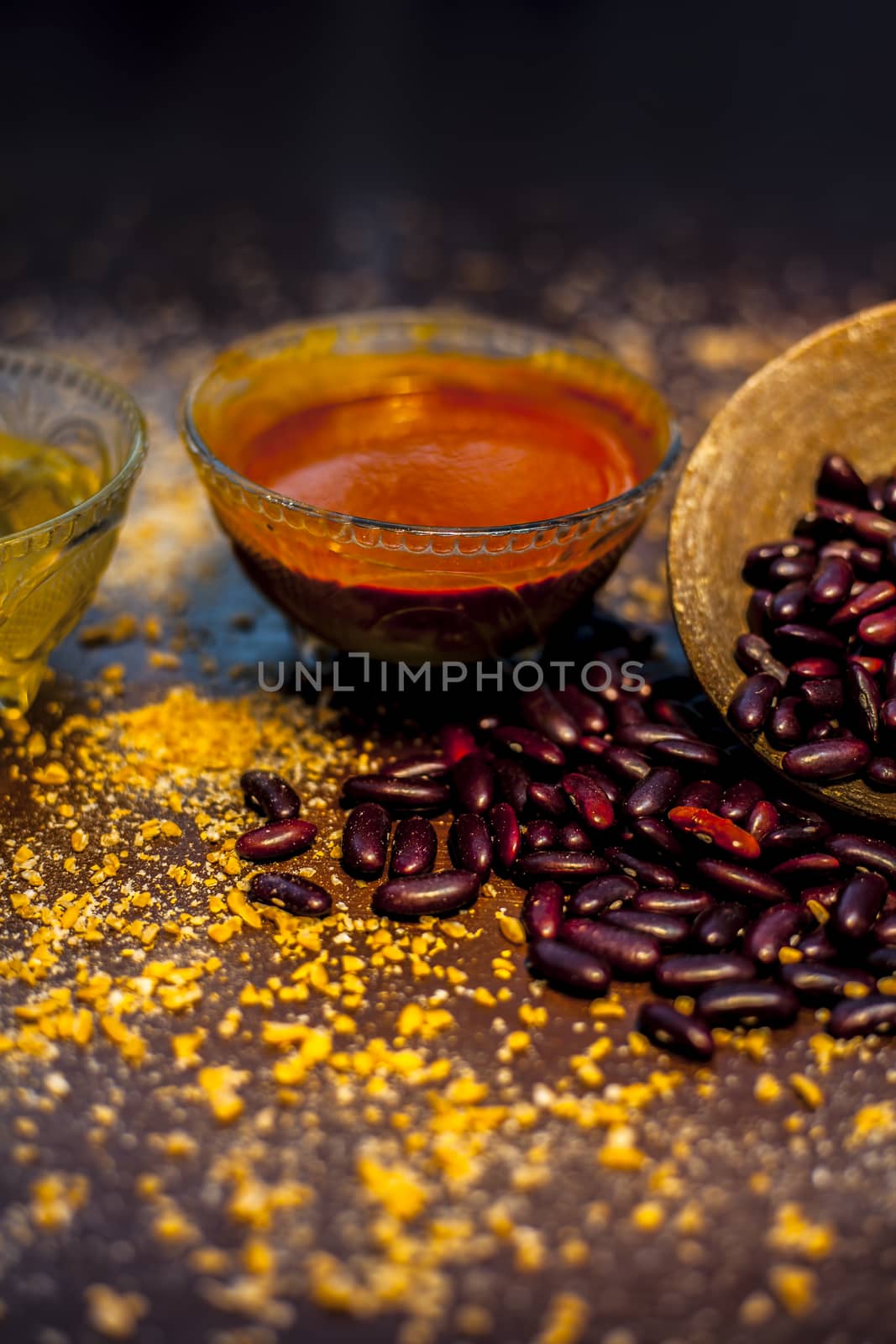 Home pore remedy on the black glossy surface consisting of some red beans or kidney beans mung beans and some green tea. Well mixed together in a bowl. Face mask for pore prevention.Vertical shot. by mirzamlk