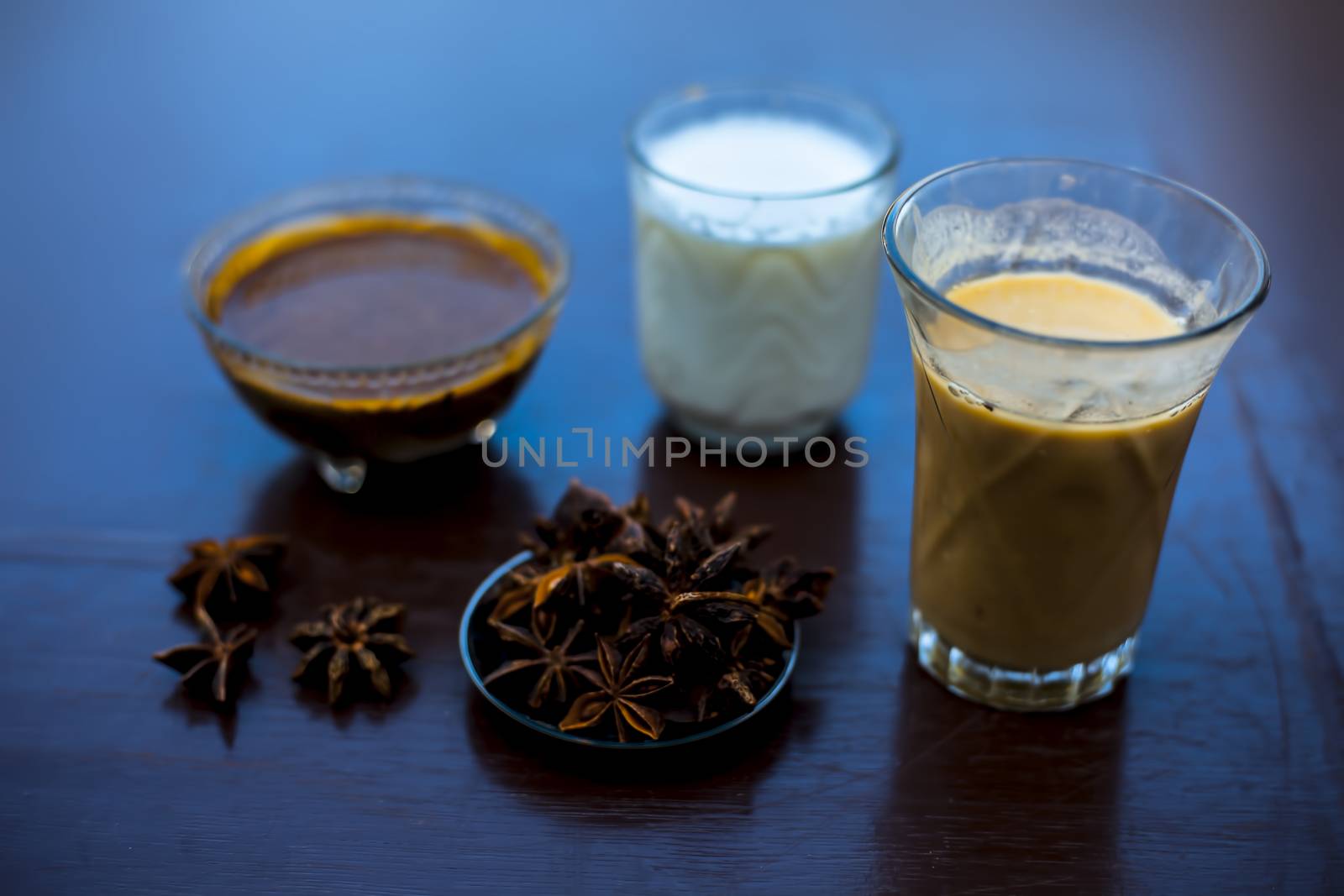 Close up shot of a glass of Star Anise Milk consisting of some star anise powder, milk, and licorice powder. Horizontal shot. by mirzamlk