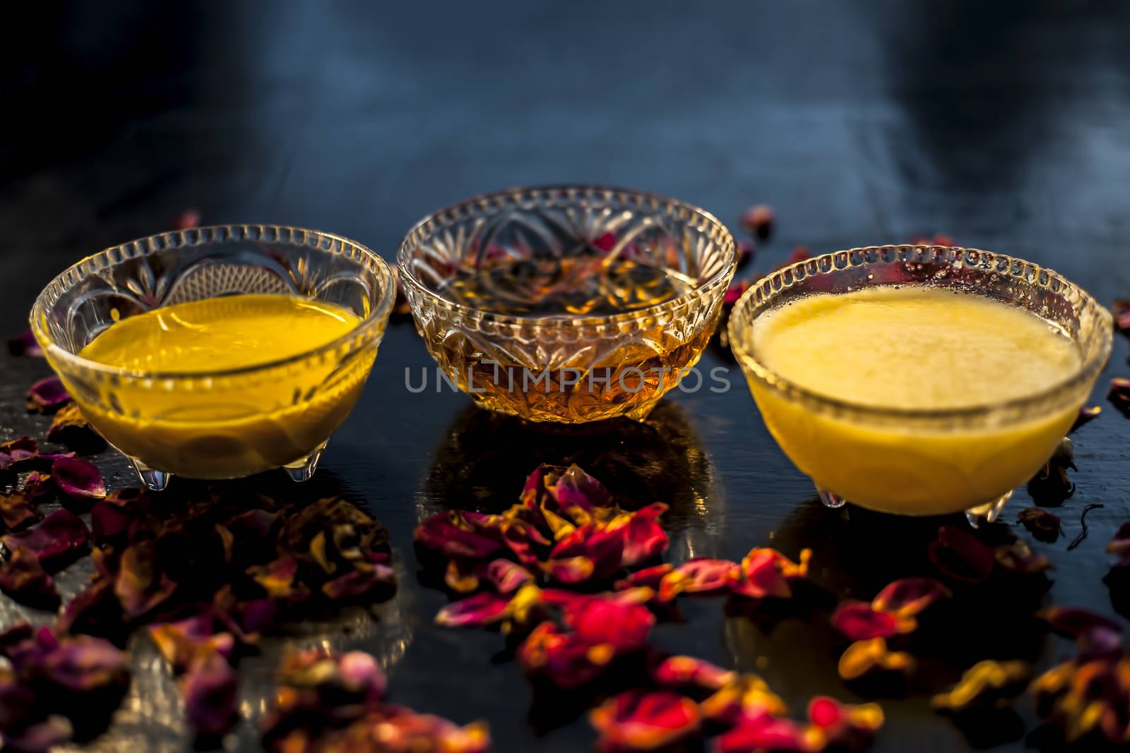 Ayurvedic moisturizer face mask on black glossy surface in a glass bowl with some ghee or clarified butter, honey and pack. by mirzamlk