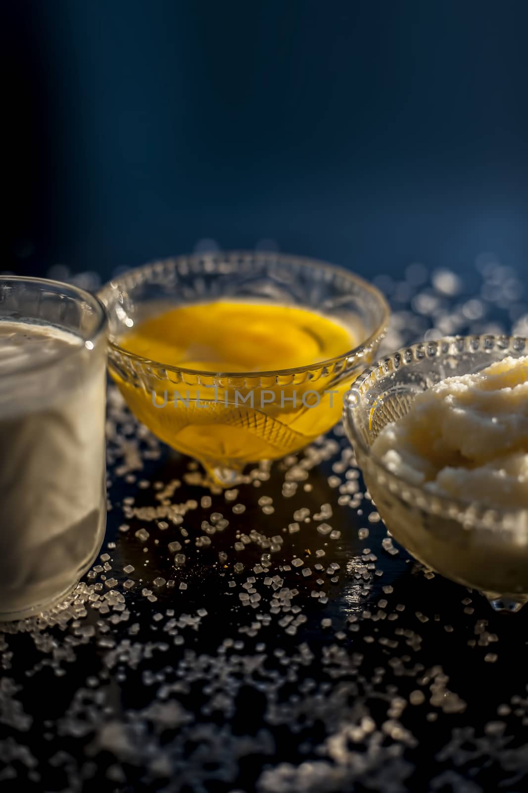 Close up shot of ayurvedic method or calcium supplement on the black surface consisting of raw eggs, milk, and ghee or clarified butter along with some sugar as a sweetener.
