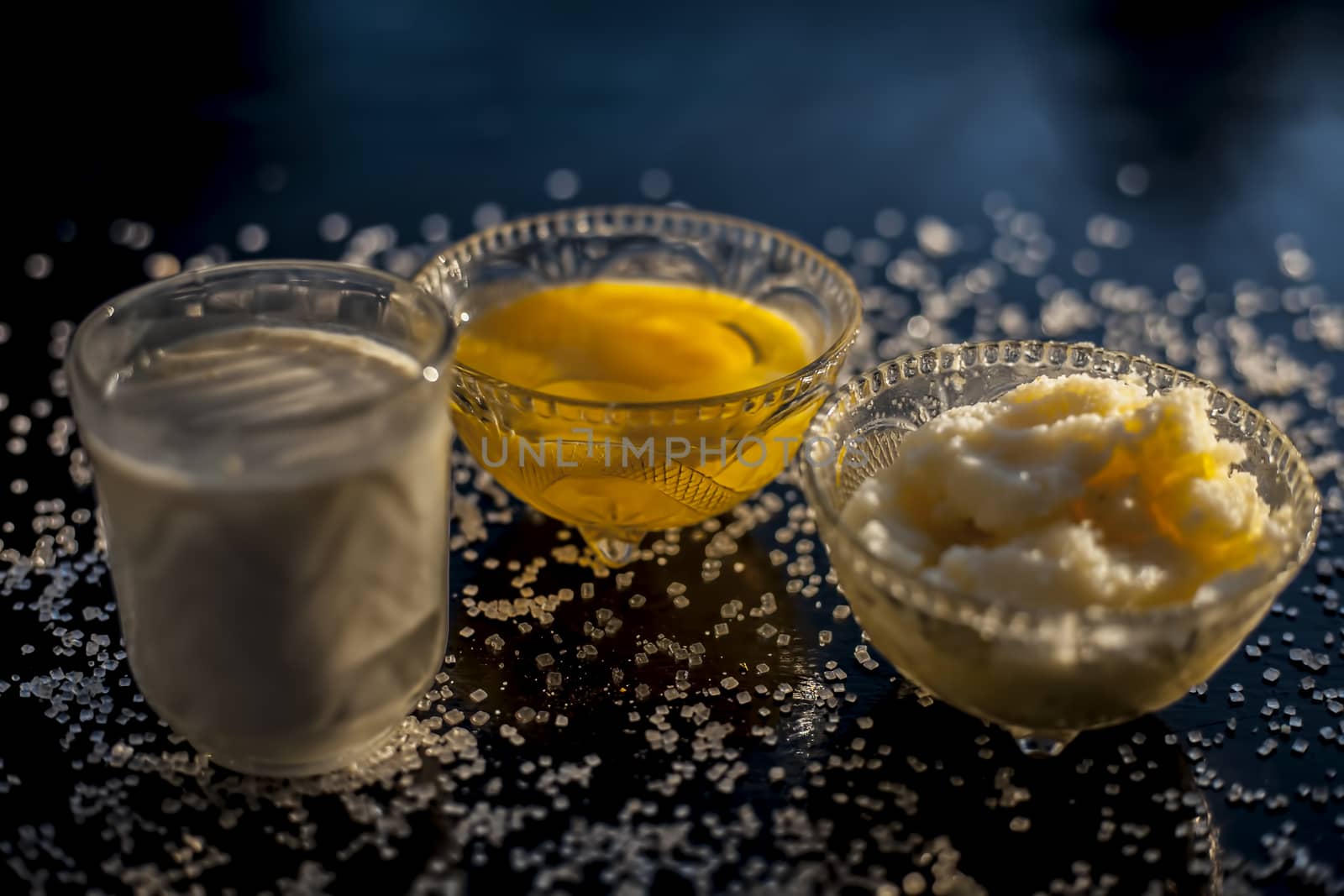 Close up shot of ayurvedic method or calcium supplement on the black surface consisting of raw eggs, milk, and ghee or clarified butter along with some sugar as a sweetener. by mirzamlk