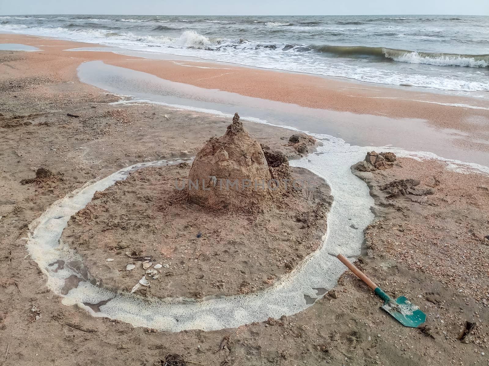 Sand castle on the beach with shells. Children's games at sea.