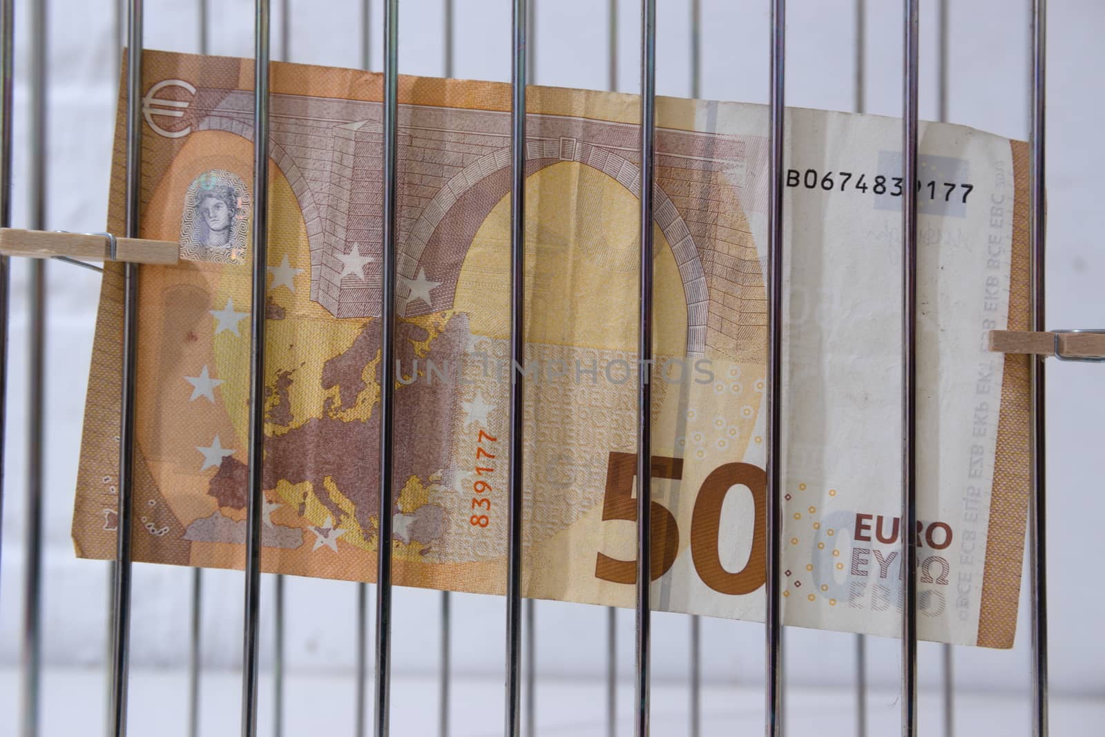 close up of fifty euro money banknote behind bars by paddythegolfer