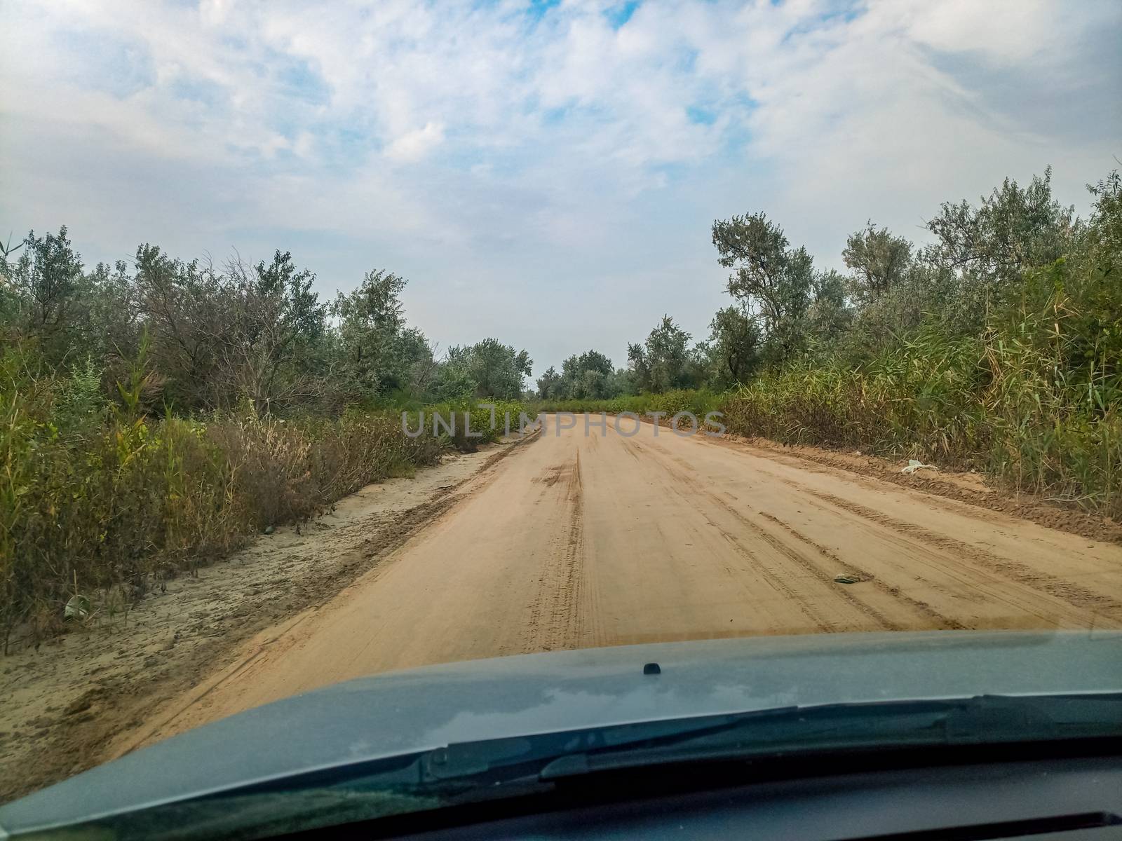 The sandy road passed by the grader. Drive on a dirt road.