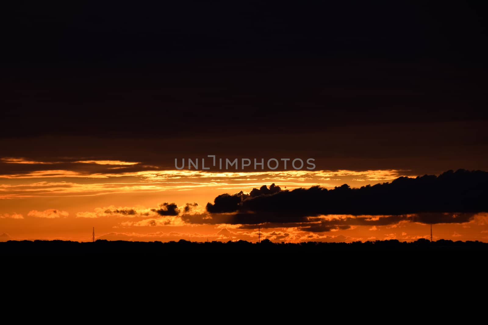 Beautiful orange bright sunset in black clouds.