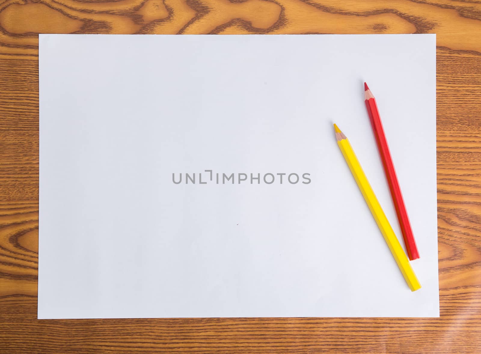 Blank white paper and color pencil on wooden table